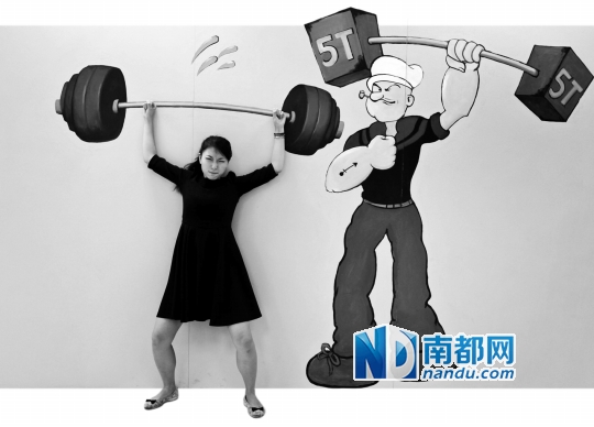 市民小杜表情有趣，仿佛画上的哑铃真的很重。