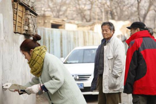 认真的美女吸引了遛弯大爷们的好奇